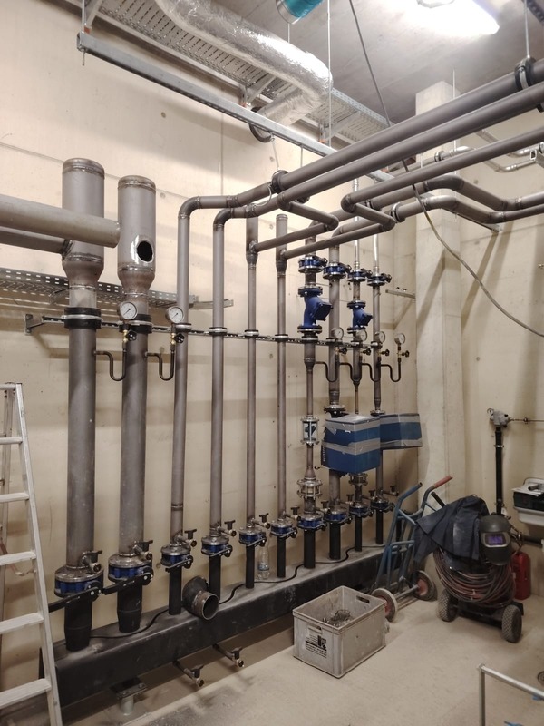 Stainless steel manifold with valves and metering in a plant room.