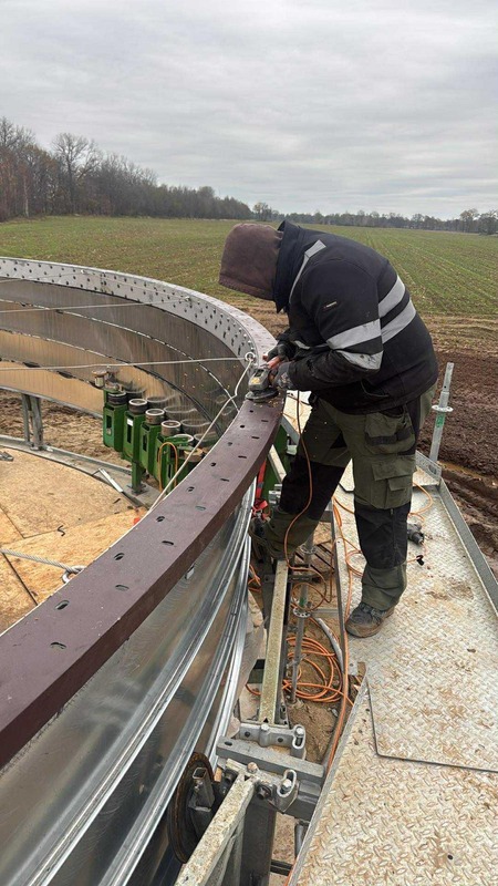 On-site welding of a curved steel ring beam for a silo structure.